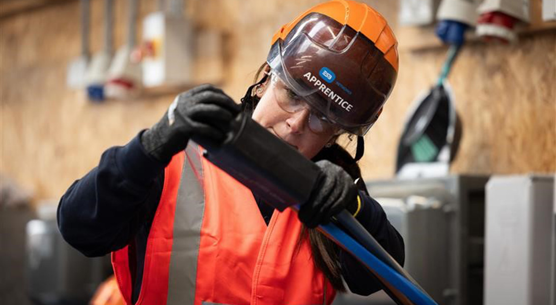 Apprentice electrician standing beside an ESB Networks van on the street