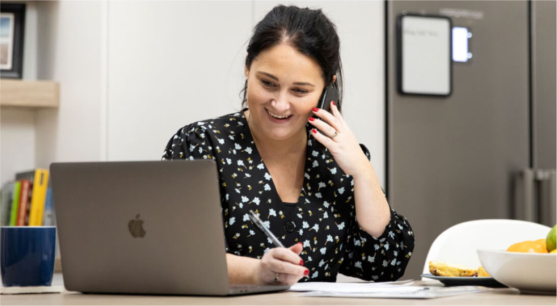 Woman on the phone looking at her laptop screen