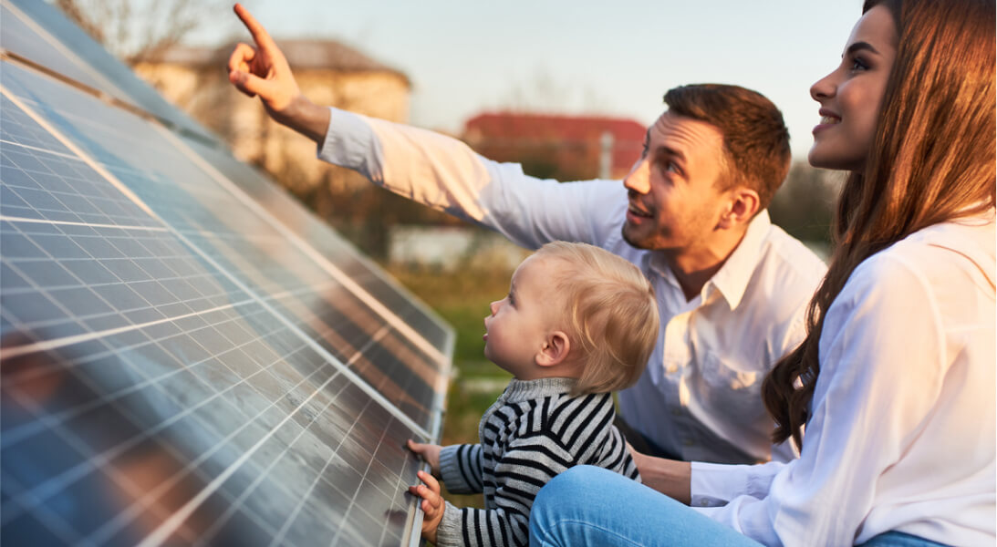 Dad and mum showing solar panels to their baby