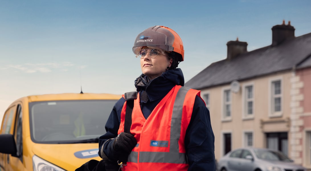 Apprentice electrician standing beside an ESB Networks van on the street