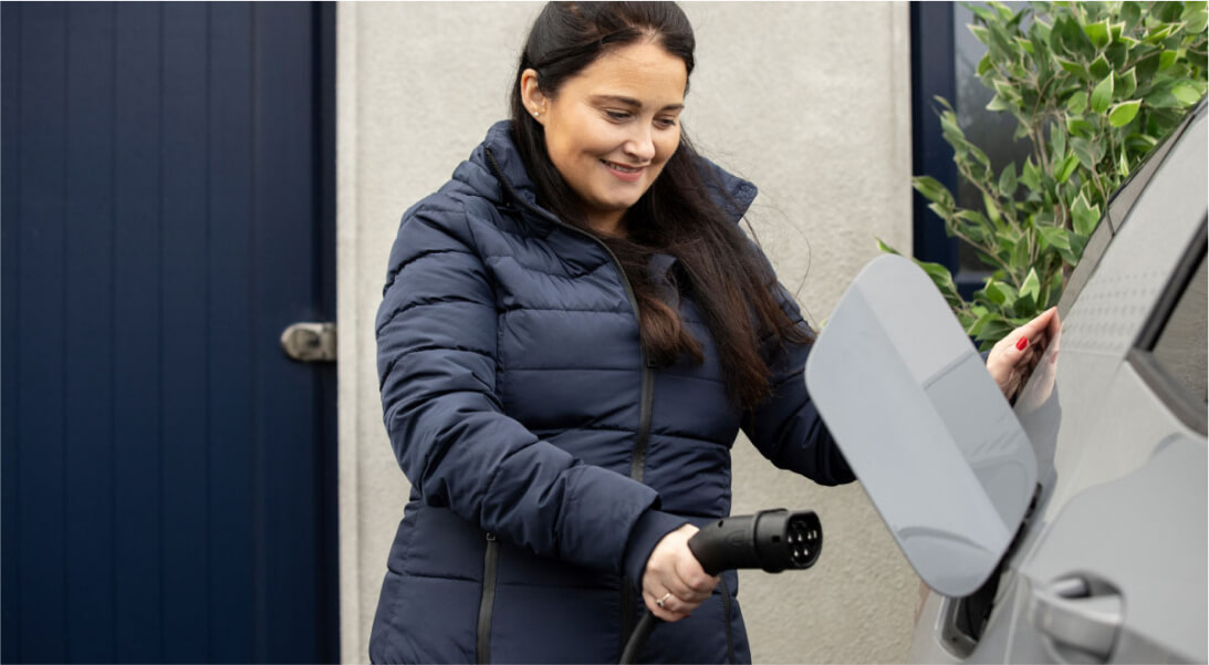 Woman holding cable to charge car