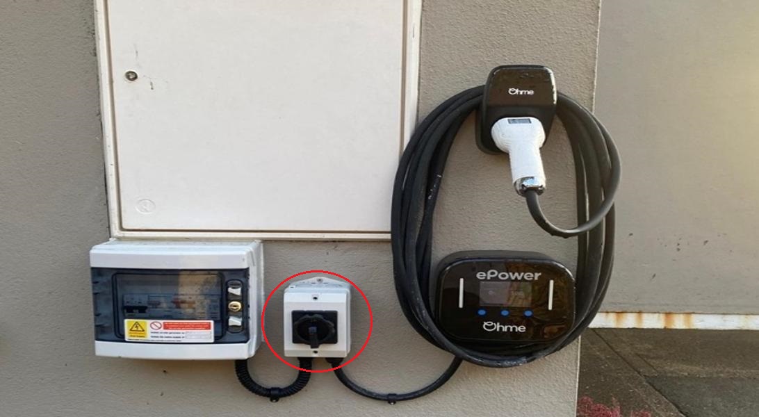 A picture of a EV charger with the isolator switch highlighted