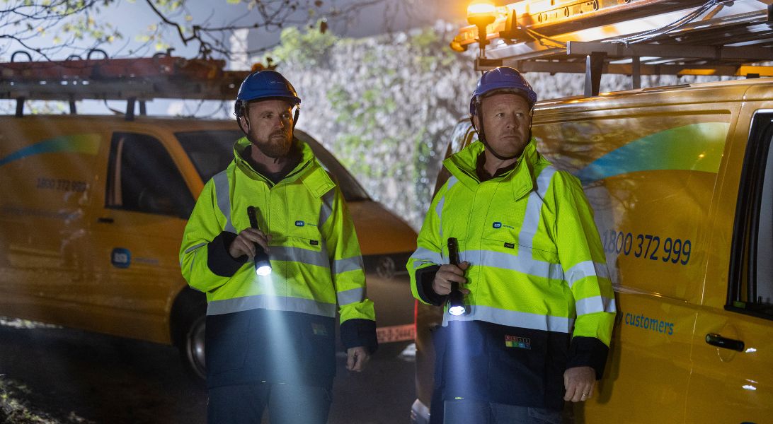 Two ESB Networks staff standing in front of vans