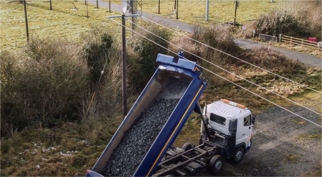 Truck emptying its load near overhead wires